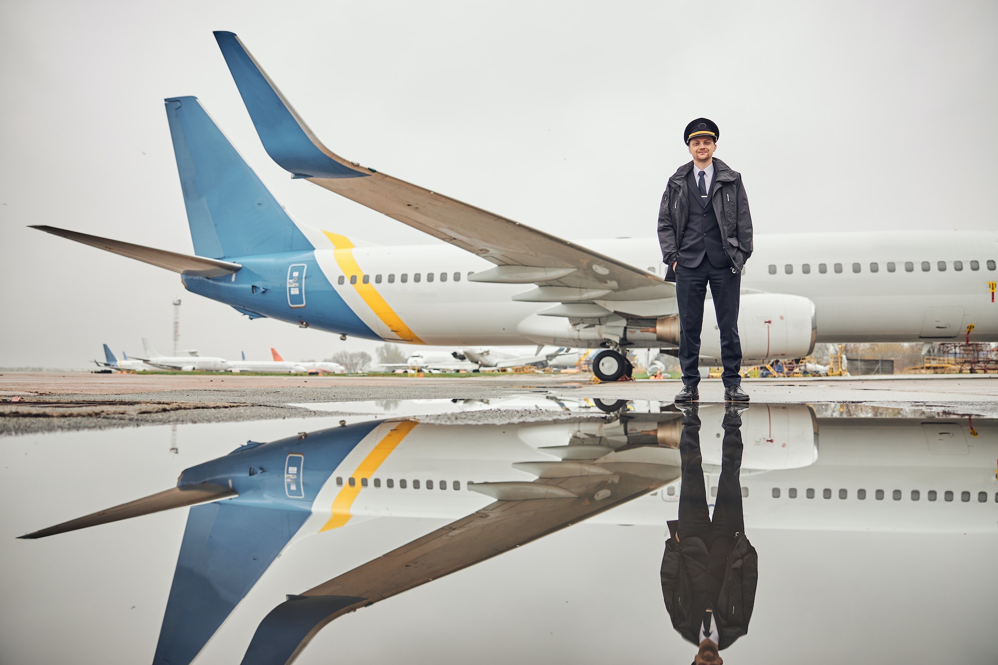 Portrait of happy confident caucasian airplane crew near plane